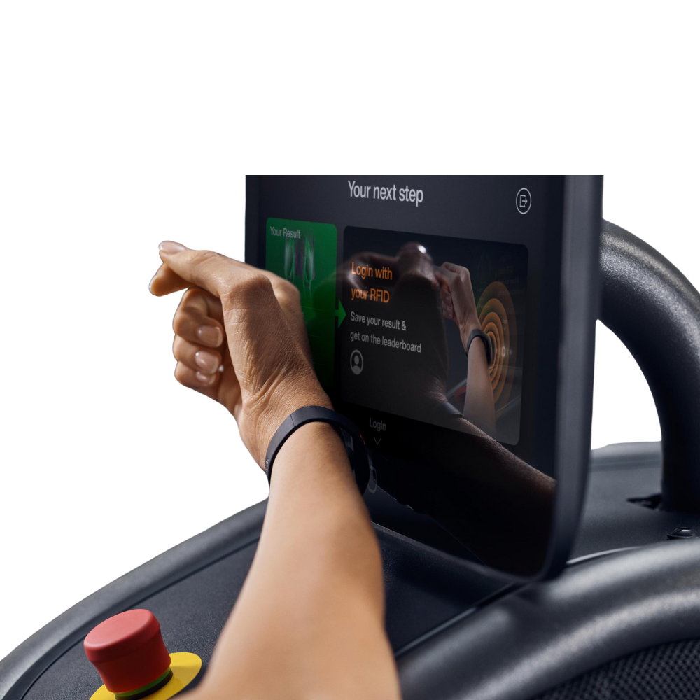 De sporter scant haar bandje bij het eGym apparaat om de workout te starten.